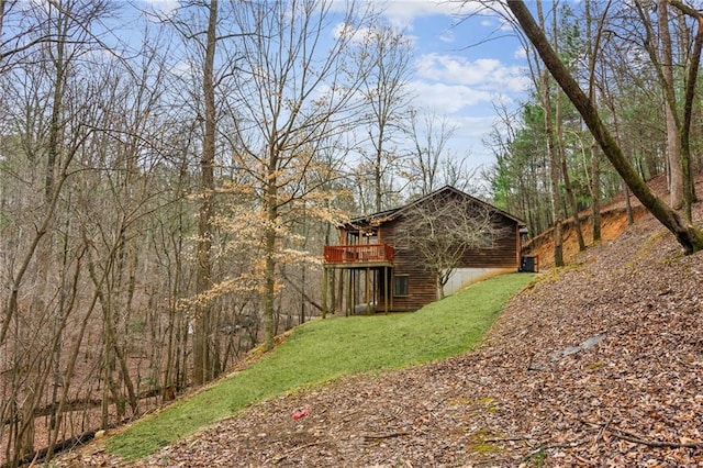 view of yard with a view of trees and a wooden deck