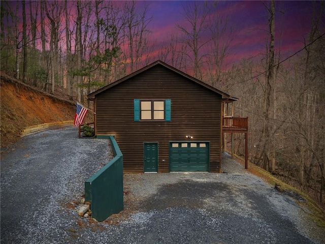 property exterior at dusk featuring a garage and driveway