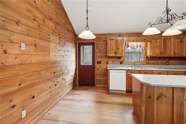 kitchen featuring lofted ceiling, white dishwasher, light wood-style floors, light countertops, and pendant lighting