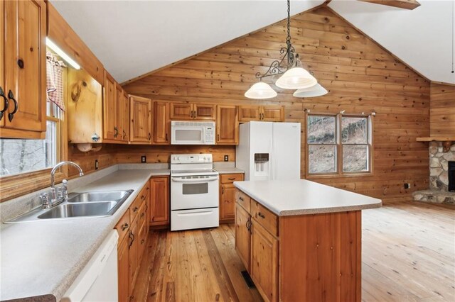 kitchen featuring a kitchen island, sink, white appliances, and decorative light fixtures