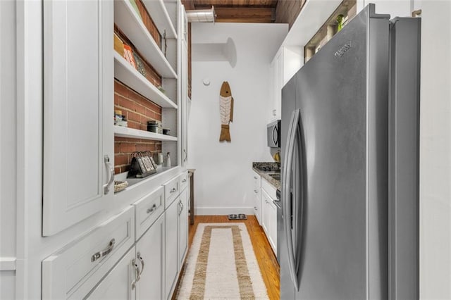 kitchen with stainless steel fridge with ice dispenser, white cabinetry, open shelves, light wood-style flooring, and baseboards