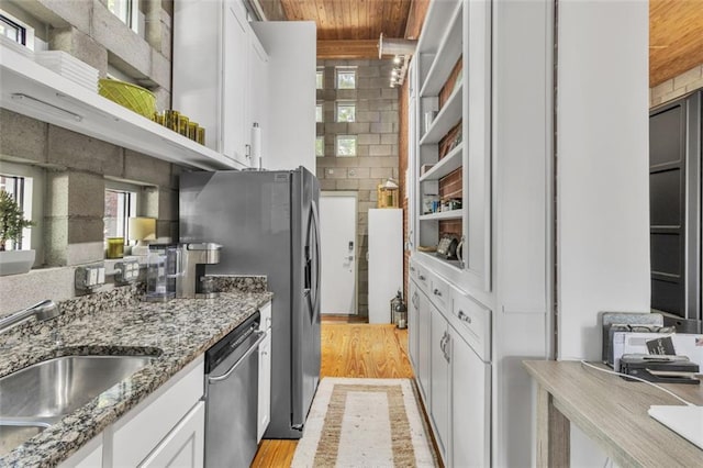 kitchen featuring appliances with stainless steel finishes, a sink, white cabinetry, wooden ceiling, and light wood-style flooring