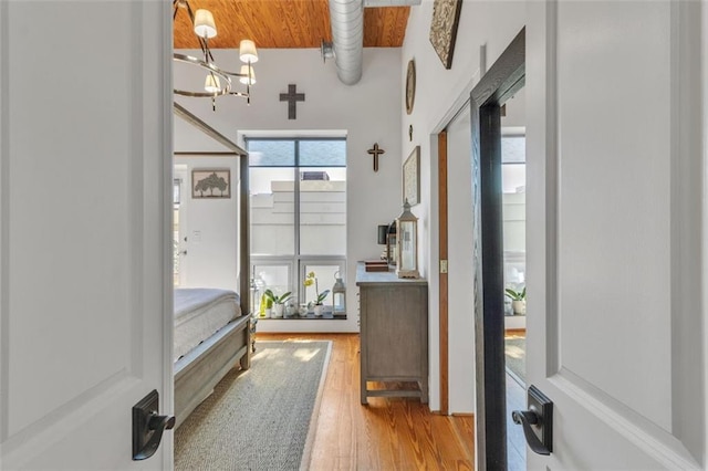 foyer entrance with a chandelier, wood finished floors, and wood ceiling