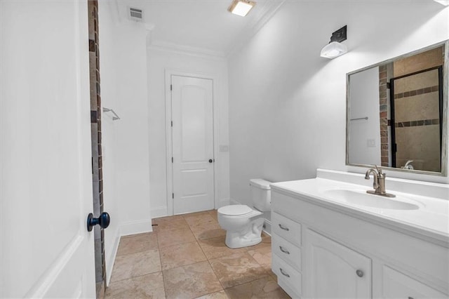 bathroom featuring vanity, toilet, ornamental molding, visible vents, and tiled shower