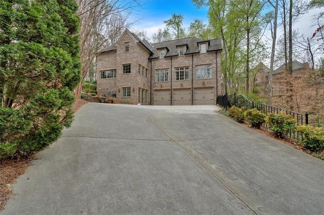view of front of home featuring an attached garage, brick siding, and concrete driveway