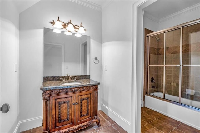 bathroom featuring tile patterned floors, crown molding, vanity, baseboards, and shower / bath combination with glass door
