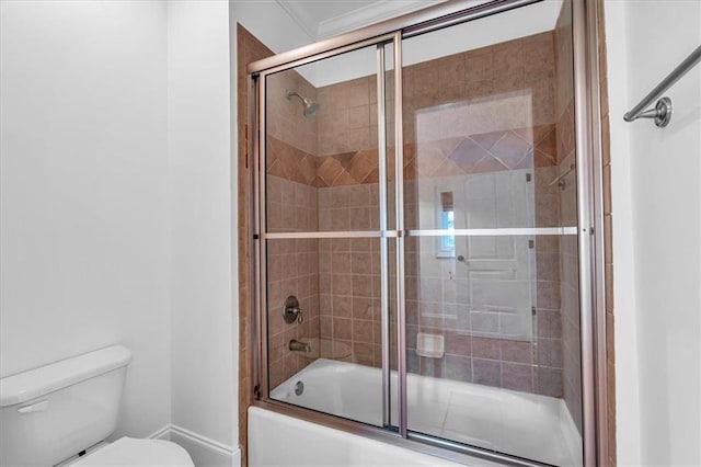 full bath with toilet and shower / bath combination with glass door
