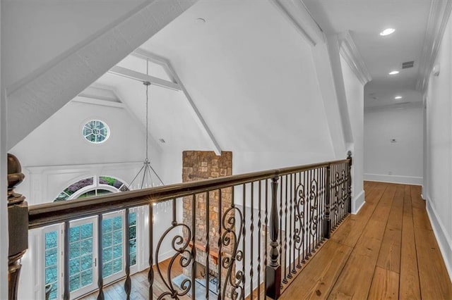 hallway featuring visible vents, baseboards, lofted ceiling, hardwood / wood-style floors, and a notable chandelier