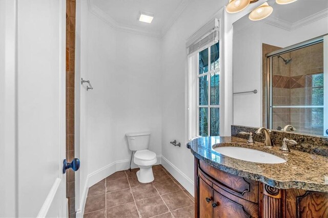 bathroom with vanity, crown molding, toilet, tile patterned floors, and tiled shower