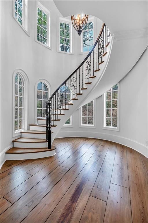 interior space featuring an inviting chandelier, stairway, and wood-type flooring