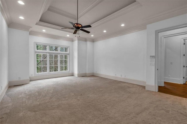 carpeted empty room featuring baseboards, a ceiling fan, ornamental molding, and a raised ceiling