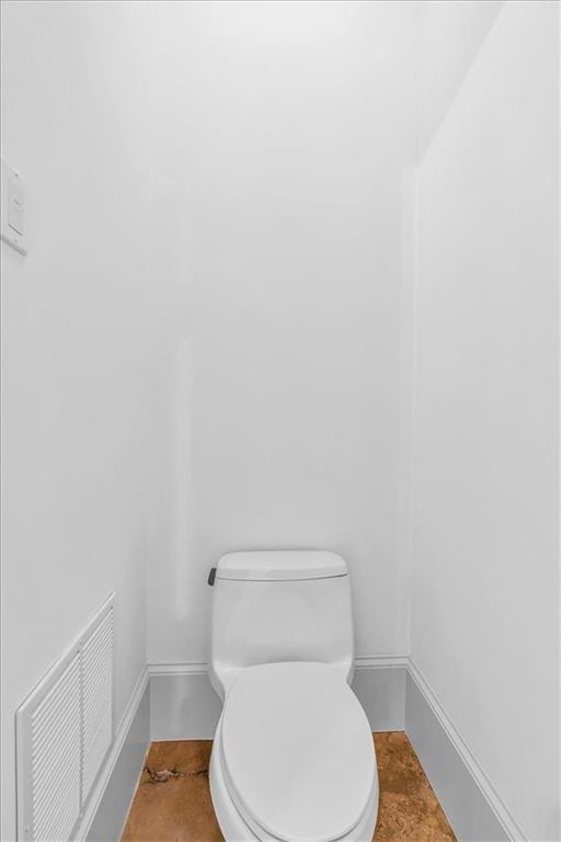 bathroom with baseboards, visible vents, and toilet