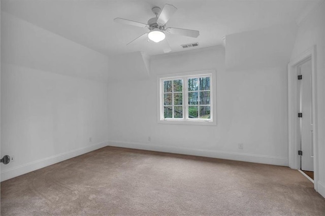 carpeted spare room featuring baseboards, visible vents, and a ceiling fan