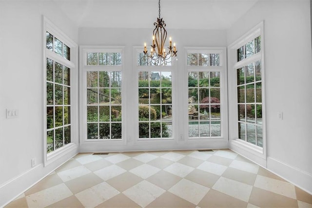 unfurnished sunroom featuring a healthy amount of sunlight and a chandelier