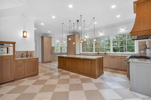 kitchen featuring crown molding, custom range hood, stainless steel appliances, a kitchen island, and light floors