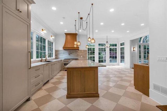 kitchen featuring a sink, light floors, a center island, custom exhaust hood, and recessed lighting