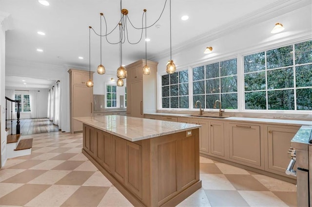 kitchen with a center island, a sink, ornamental molding, and light floors