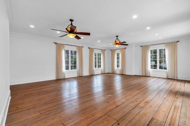 spare room featuring baseboards, ornamental molding, recessed lighting, a ceiling fan, and light wood-style floors