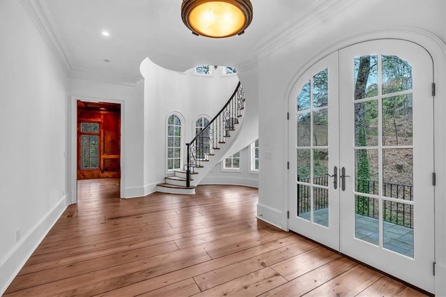 foyer featuring french doors, ornamental molding, and wood-type flooring