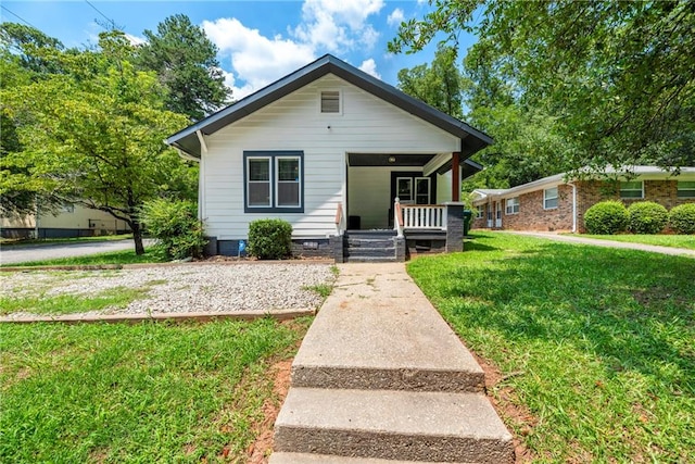 bungalow-style house with a front lawn and covered porch