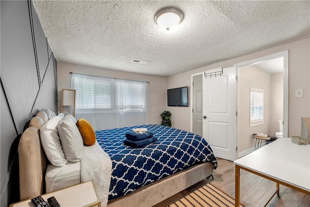 bedroom with hardwood / wood-style floors and a textured ceiling