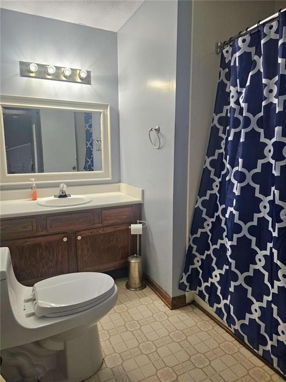 bathroom featuring vanity, toilet, and a textured ceiling