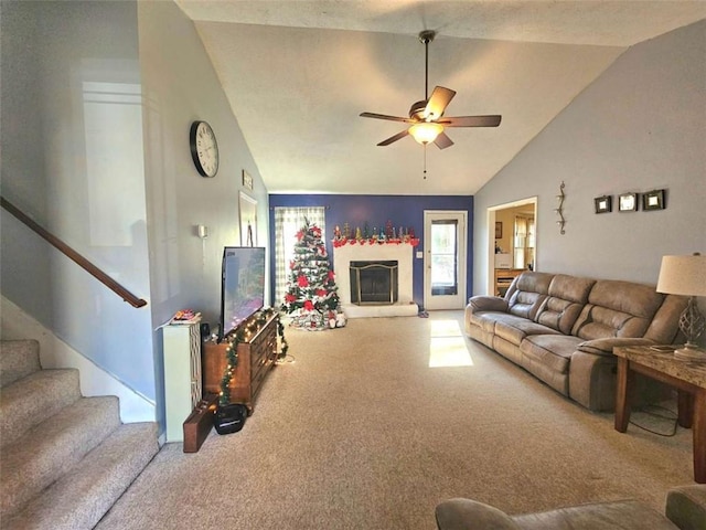 carpeted living room with ceiling fan and vaulted ceiling