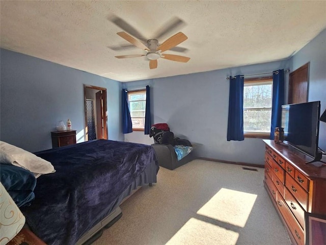 bedroom featuring multiple windows, ceiling fan, and light colored carpet