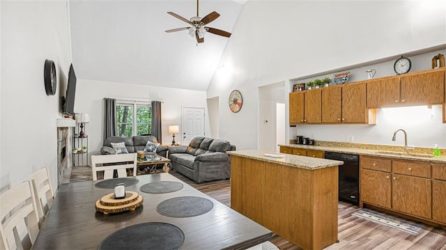 kitchen featuring sink, hardwood / wood-style flooring, high vaulted ceiling, dishwasher, and a kitchen island