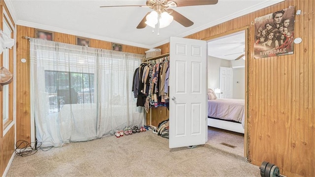 bedroom with carpet, wooden walls, a closet, and ceiling fan