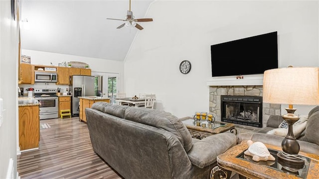 living room with ceiling fan, a fireplace, high vaulted ceiling, and dark wood-type flooring