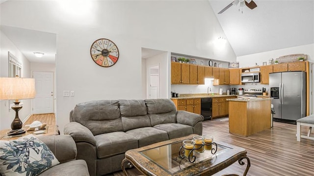 living room with ceiling fan, sink, high vaulted ceiling, and light wood-type flooring