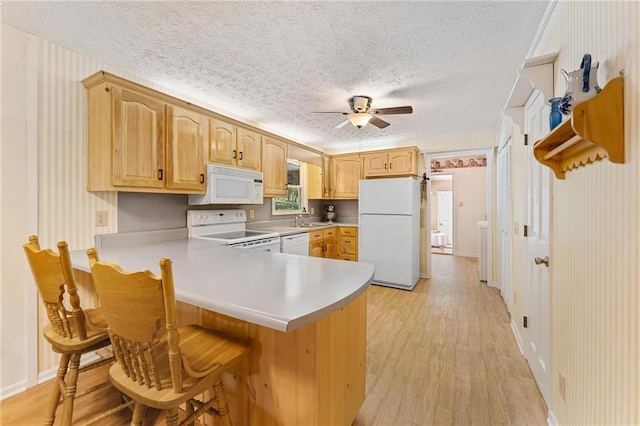 479 Deerpath Dr, Sautee Nacoochee, GA 30571 - kitchen with white appliances, a textured ceiling, light wood-style flooring, a peninsula, and a ceiling fan