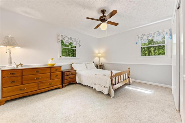479 Deerpath Dr, Sautee Nacoochee, GA 30571 - bedroom featuring multiple windows, light colored carpet, a textured ceiling, and a ceiling fan