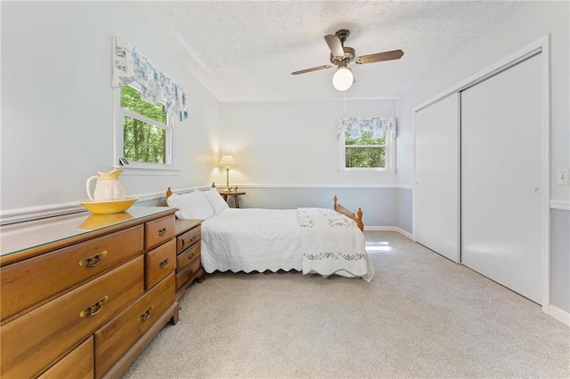 479 Deerpath Dr, Sautee Nacoochee, GA 30571 - bedroom featuring multiple windows, a closet, a textured ceiling, light colored carpet, and ceiling fan