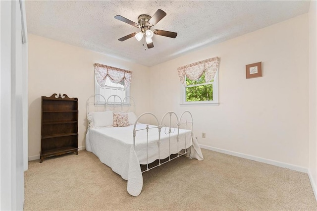 479 Deerpath Dr, Sautee Nacoochee, GA 30571 - bedroom featuring multiple windows, light carpet, a textured ceiling, and ceiling fan