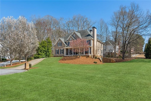 back of property featuring a lawn and a chimney