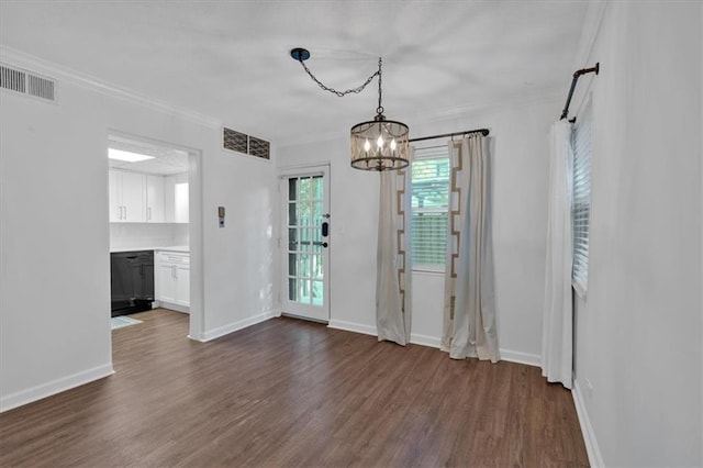 unfurnished dining area featuring dark wood finished floors, visible vents, and crown molding