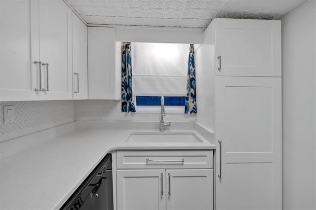 kitchen featuring dishwasher, light countertops, a sink, and white cabinets