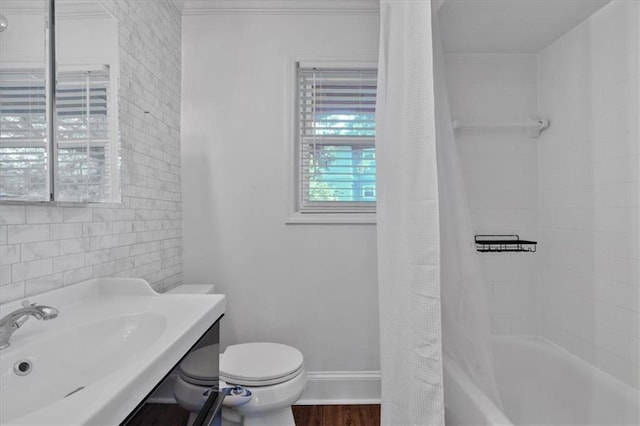 full bathroom with toilet, wood finished floors, vanity, baseboards, and shower / tub combo with curtain