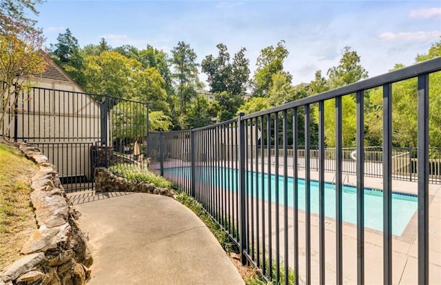 community pool featuring fence and a patio