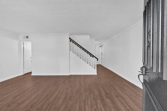 unfurnished living room with stairs, ornamental molding, dark wood-style floors, and baseboards