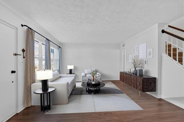 living room with a textured ceiling, stairs, ornamental molding, and wood finished floors