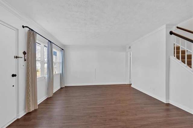 empty room with dark wood-type flooring, ornamental molding, a textured ceiling, baseboards, and stairs