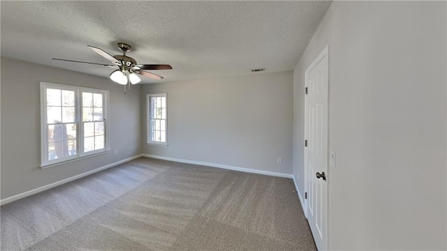 spare room featuring a textured ceiling, carpet floors, and ceiling fan