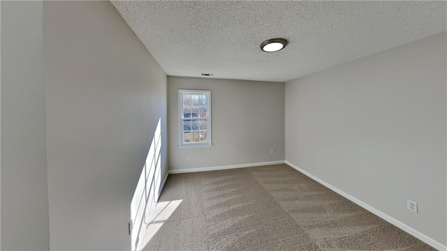 unfurnished room featuring carpet flooring and a textured ceiling