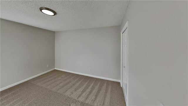 empty room featuring carpet and a textured ceiling