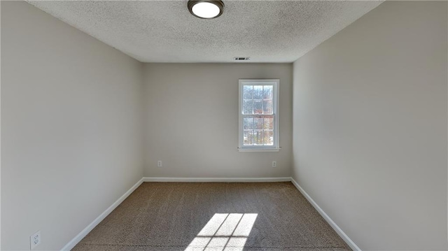 spare room with carpet and a textured ceiling