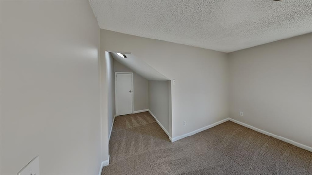 bonus room featuring light colored carpet and a textured ceiling