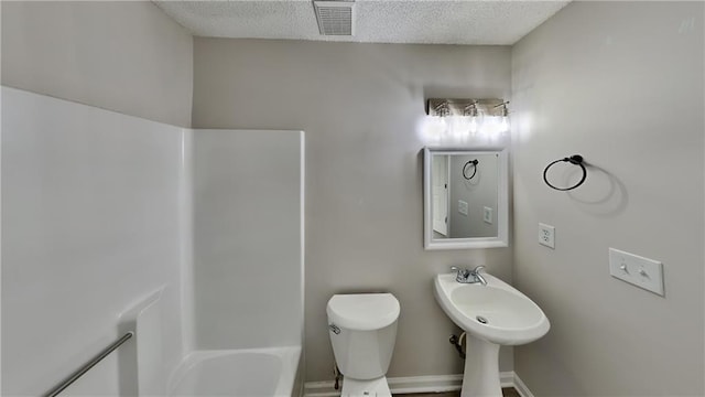 bathroom featuring a textured ceiling, toilet, and sink